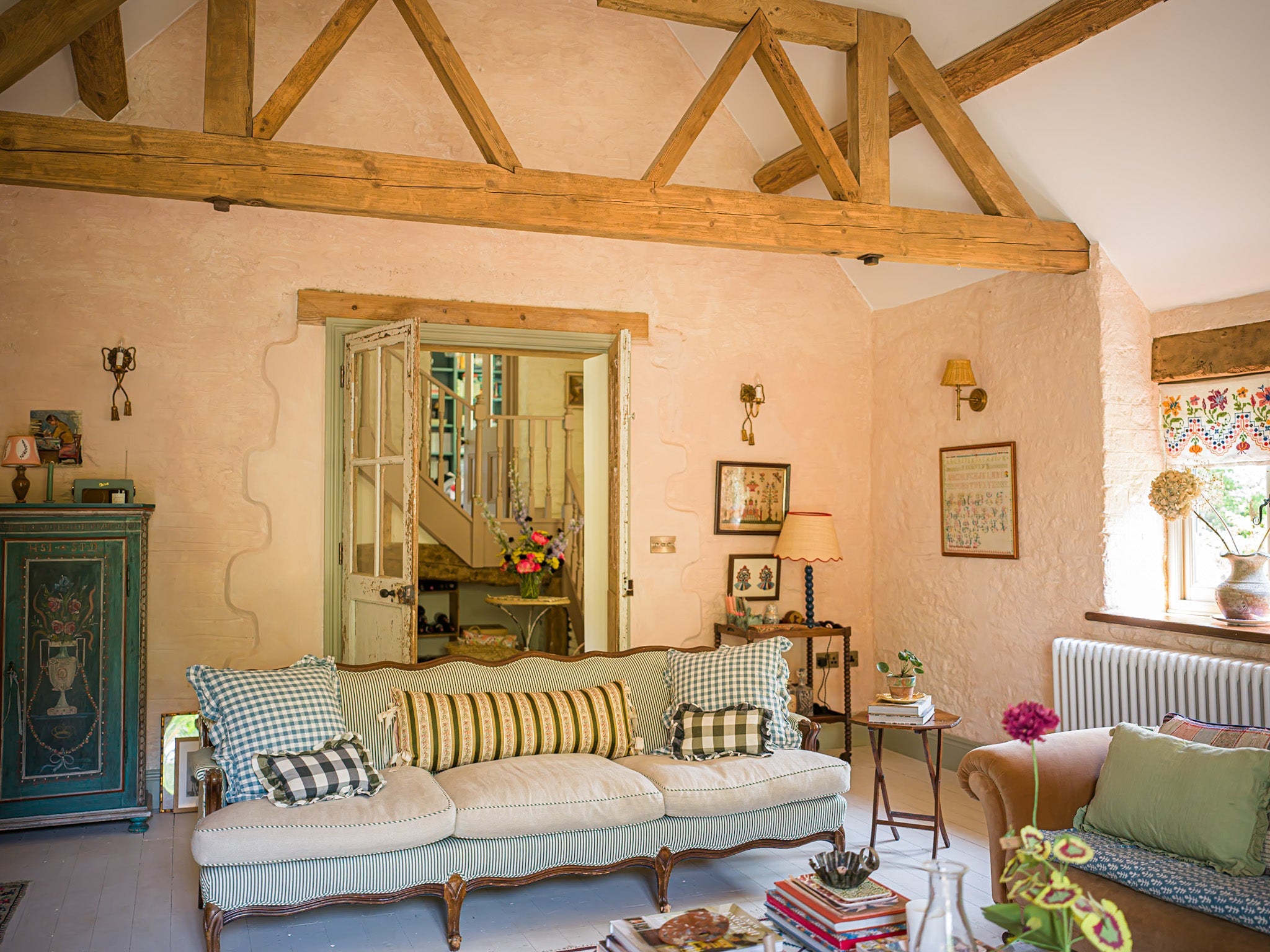 a lovely antique chair with a blue ruffled cushion in an airy, warm, sunlit room in a cotswolds manner house