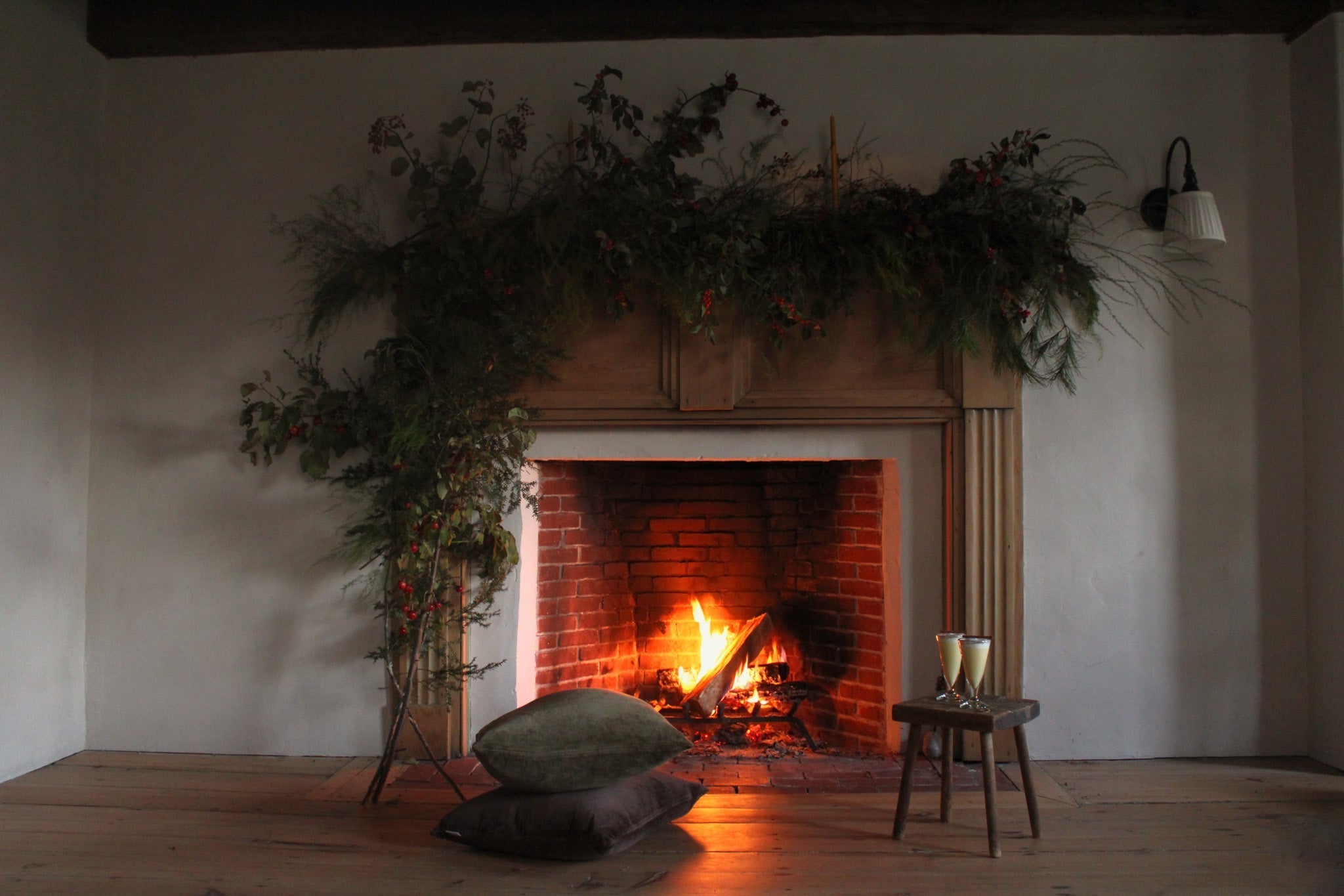 a roaring fire with a styled mantle, cosy floor cushions and homemade eggnog