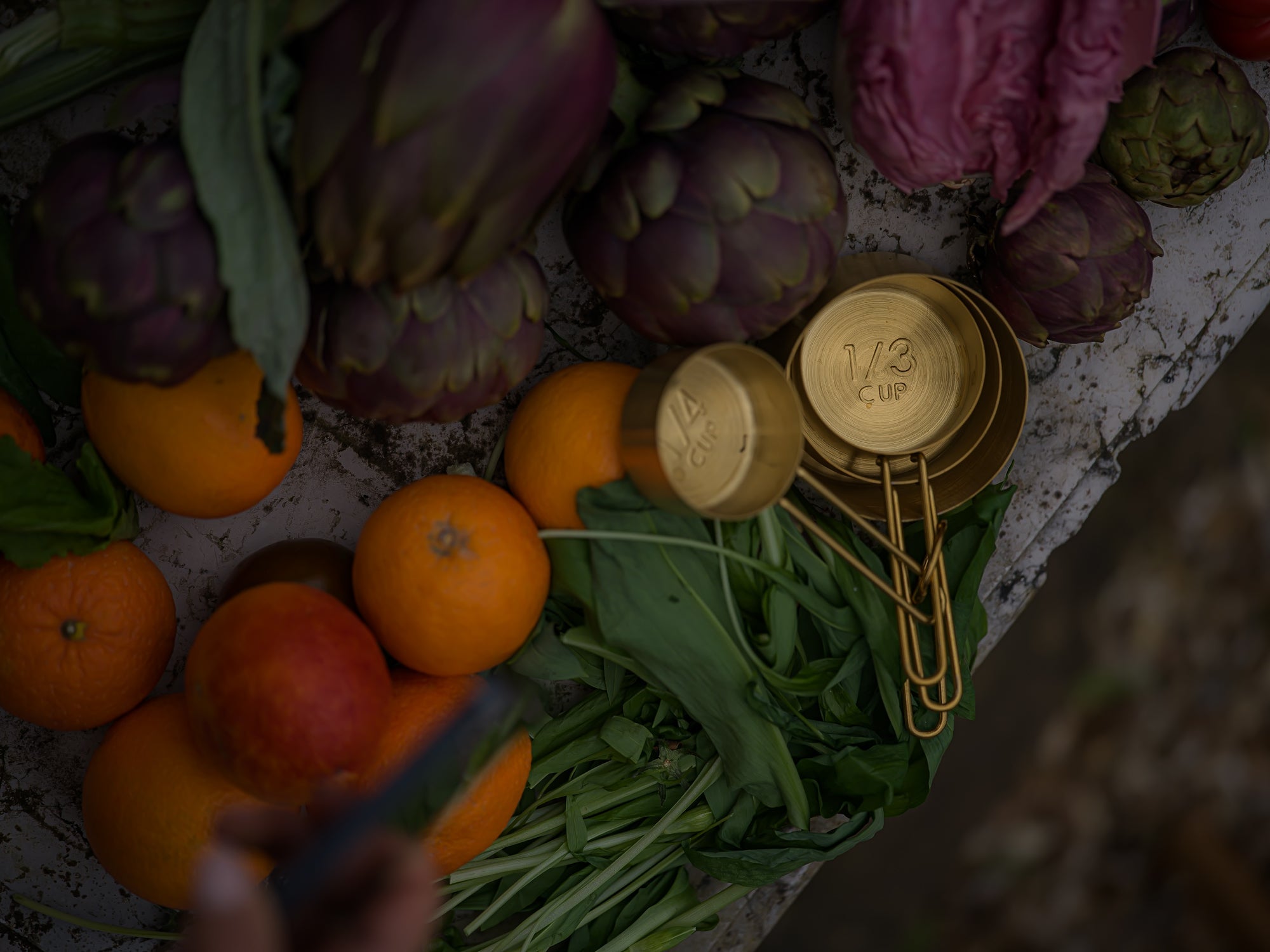 a table of fresh garden produce with gold measuring cups