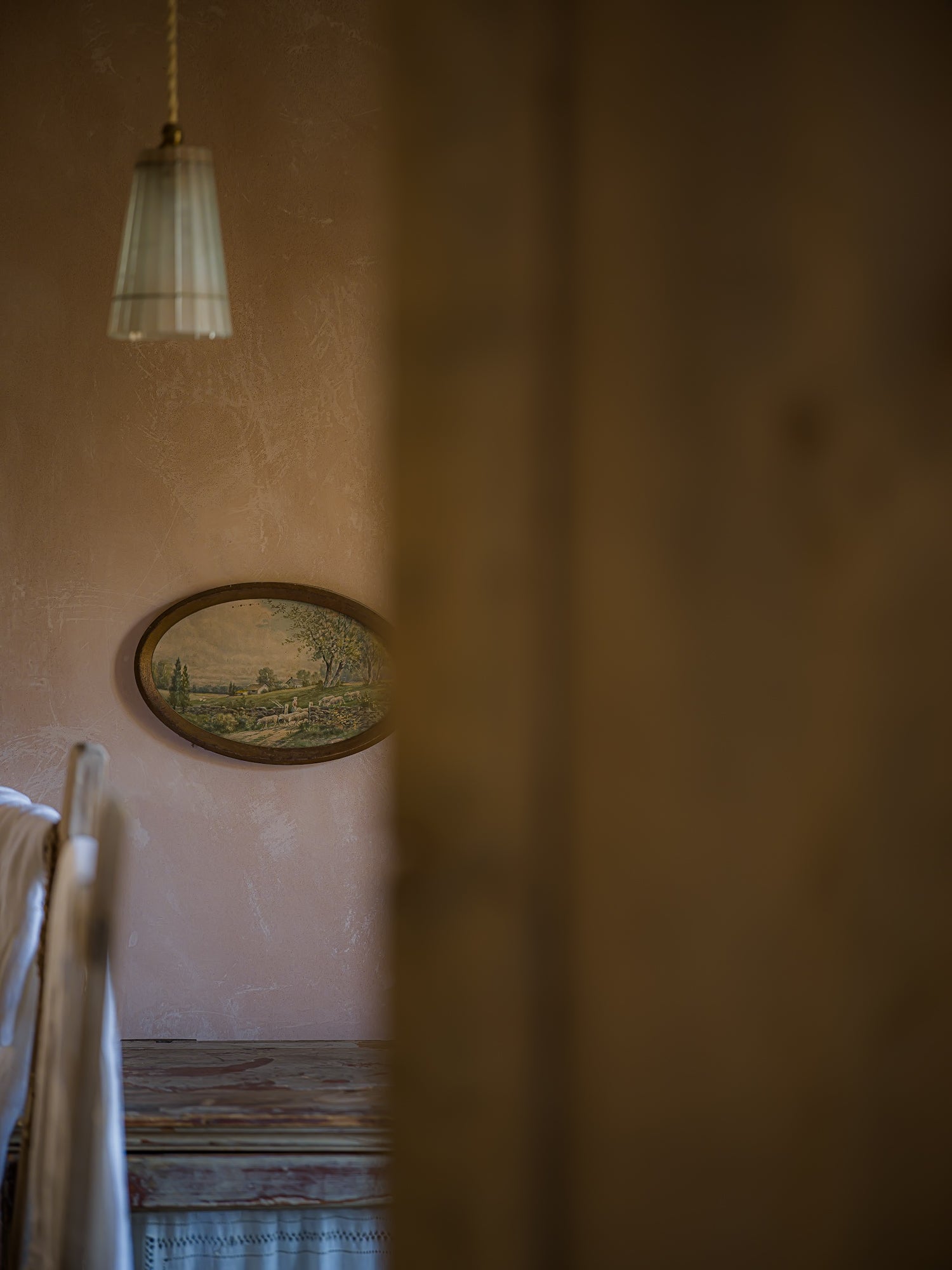 a handwoven hamper basket sits in the doorway of a cottage, leading outside to a spring garden