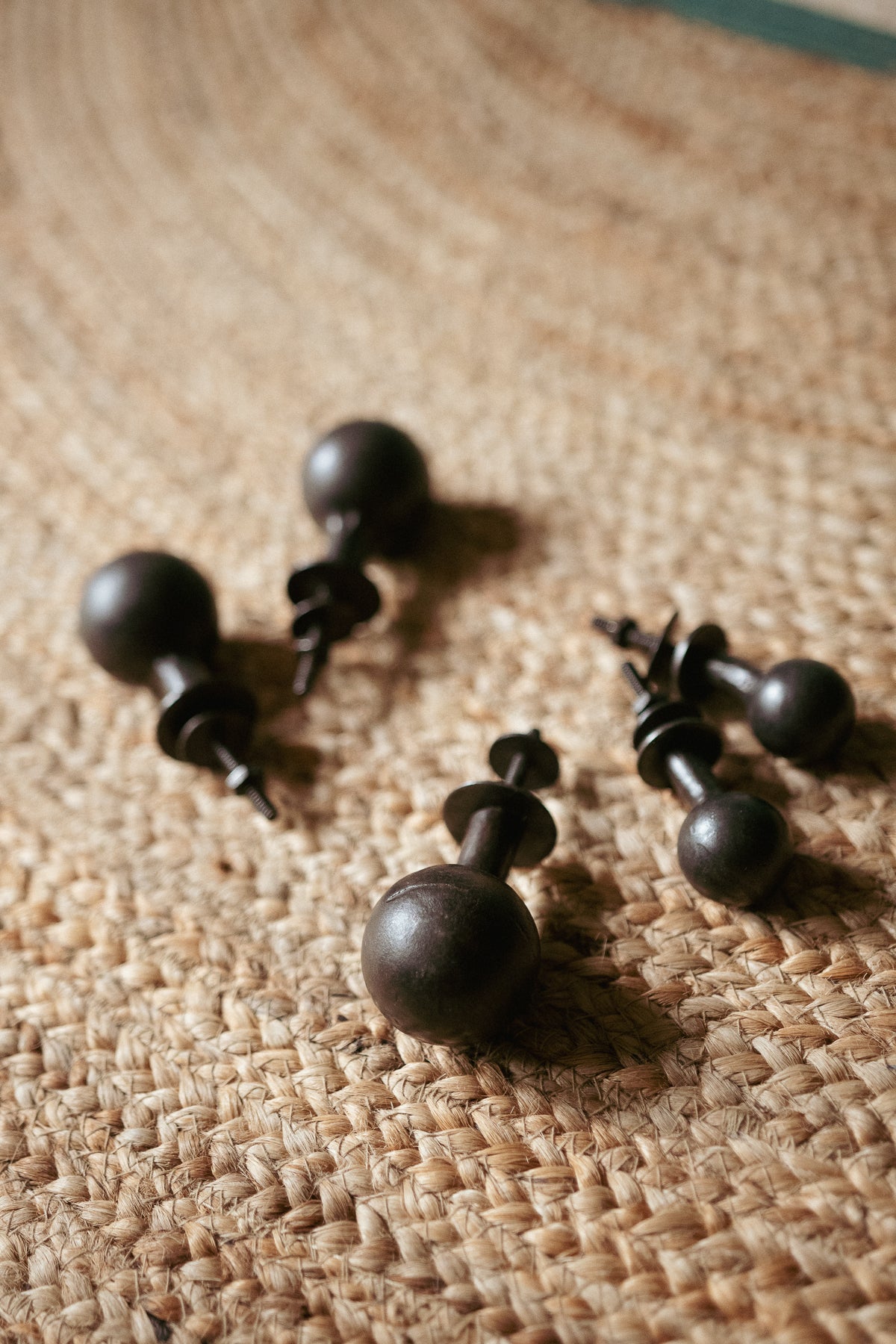 Set of black wooden knobs on a textured beige surface