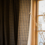 Plaid curtain in front of a window with natural light