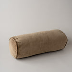 A cylindrical bolster pillow in a textured taupe fabric, photographed on a neutral light gray background.